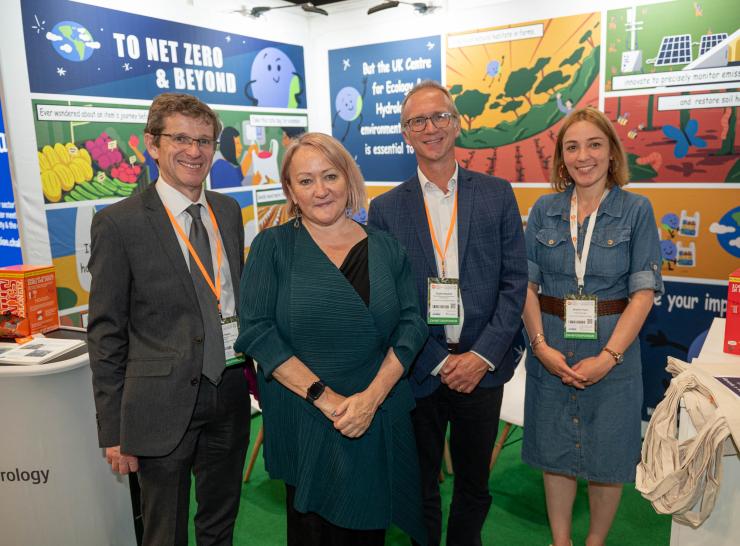 Group of four in front of an exhibition stand