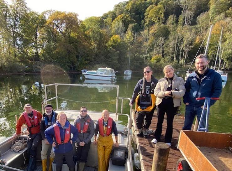 Group of researchers standing on and beside the John Lund vessel on Windermere