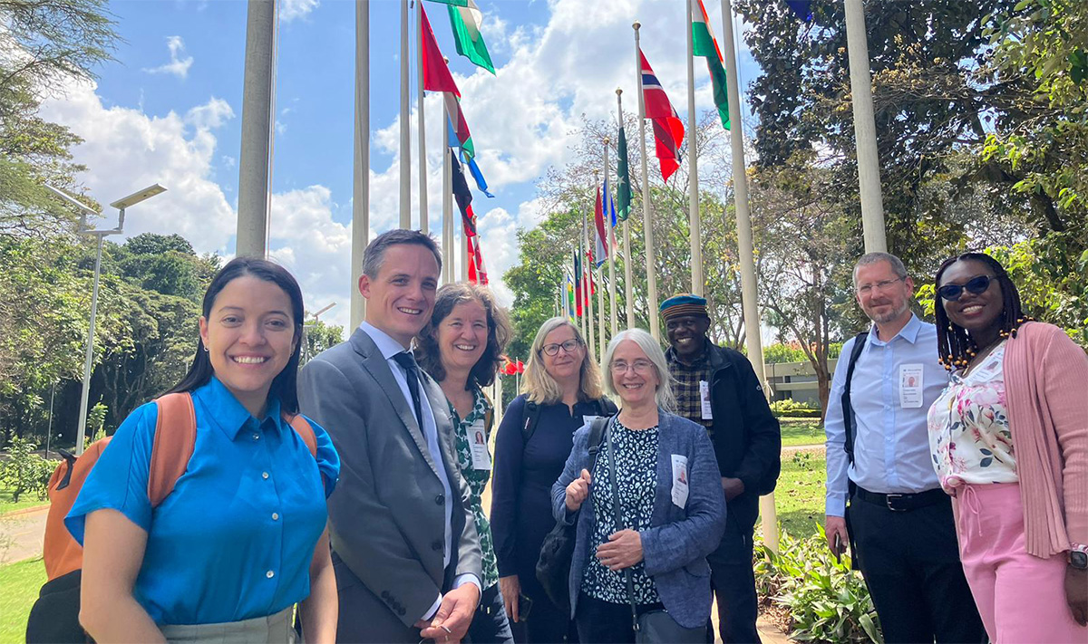 UKCEH delegation standing on paths lined by international flags