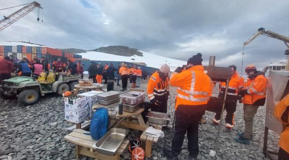 Large group of people outdoors in warm clothing having a barbecue