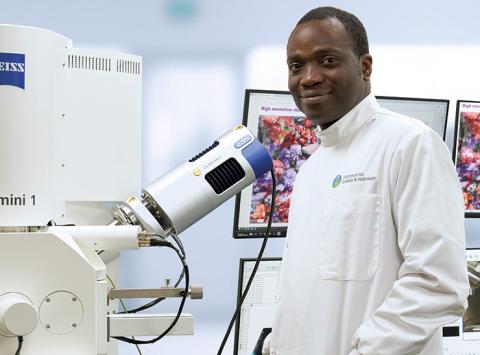 Dr Gbotemi Adediran stands beside the CoreMiS equipment