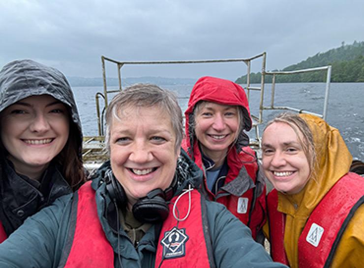 Four people on a boat on Windermere on a wet day