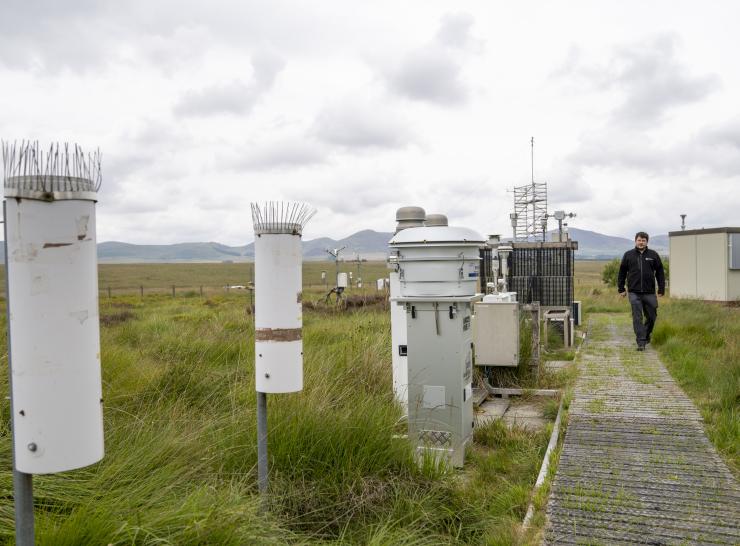 A researcher looks at large scientific instruments at Auchencorth Atmospheric Observatory